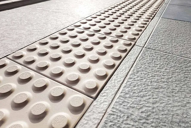 Taktile Pflastersteine am Bahnsteig mit Braille-Block (Noppen) zur Orientierung im öffentlichen Raum